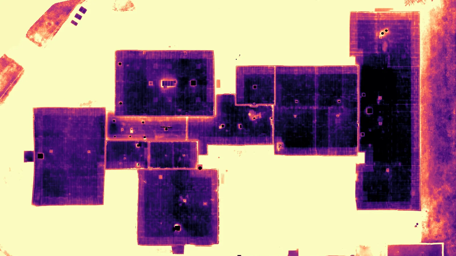 Matched thermal orthomosaic of the same roof from directly above, DJI Matrice 30T, magma palette.